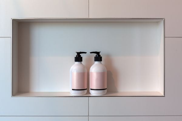 Professionally installed metal tile trim on the edge of a white subway tile wall.