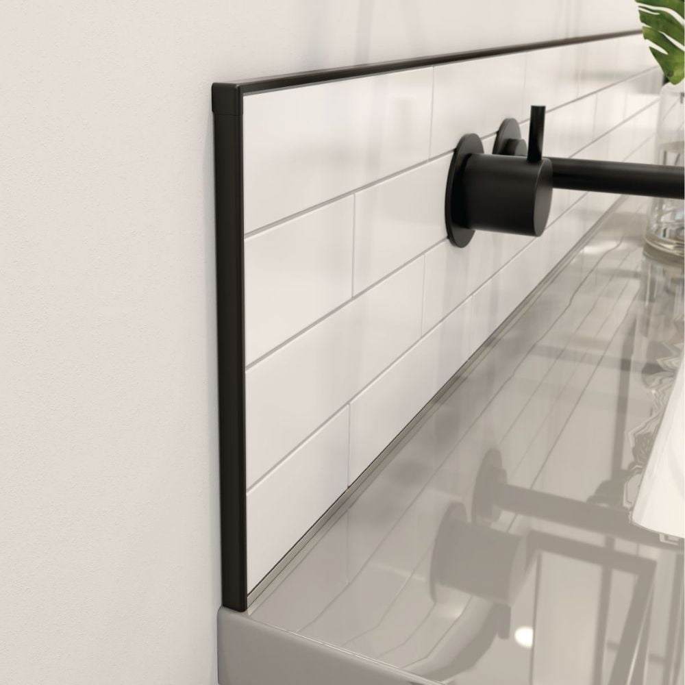 Black trim finishing the exposed edges of a white tiled backsplash