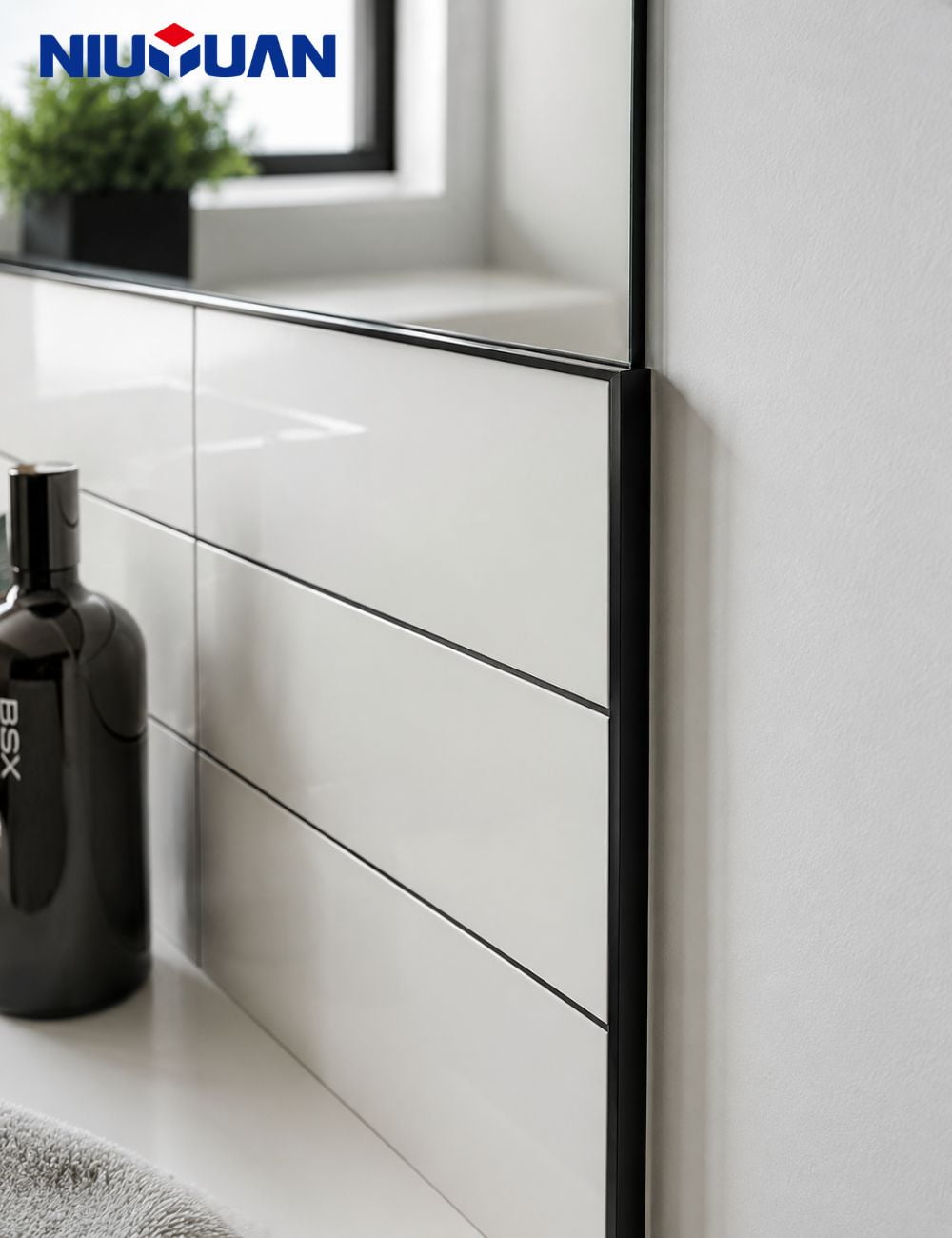 Matte black aluminum tile trim on a bathroom wall edge