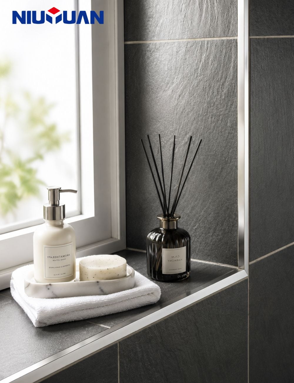 Bright polished aluminum tile trim edging a dark tiled bathroom corner
