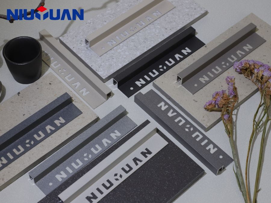 Light, dark and metallic tile-trim samples arranged beside different tile finishes