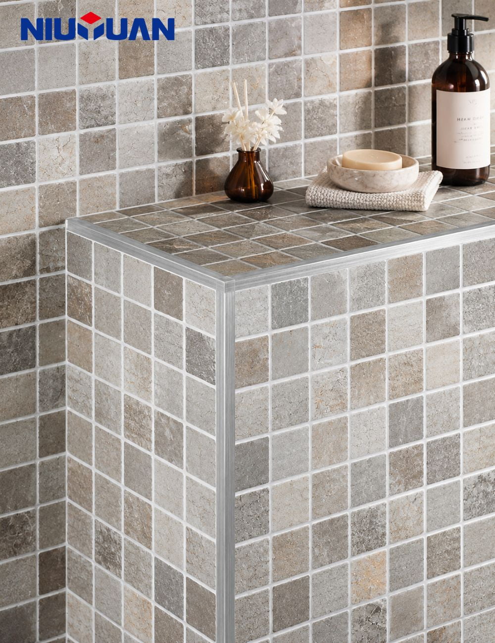 Brushed metal tile trim finishing a tiled bathroom corner