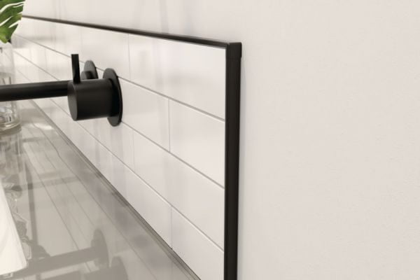 Black tile trim bordering a finished white tiled backsplash